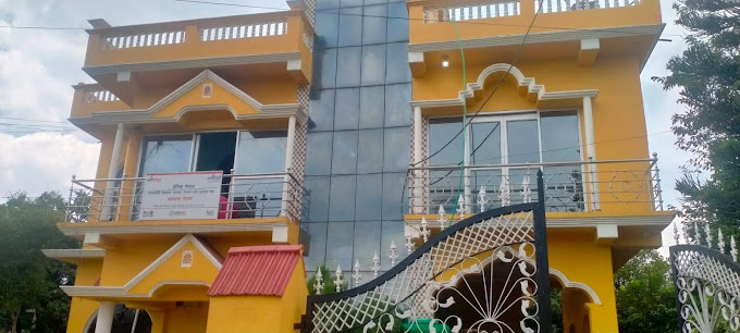 orange building with elaborate gate and many windows, there's a viewing platform on the roof and the middle is all glass